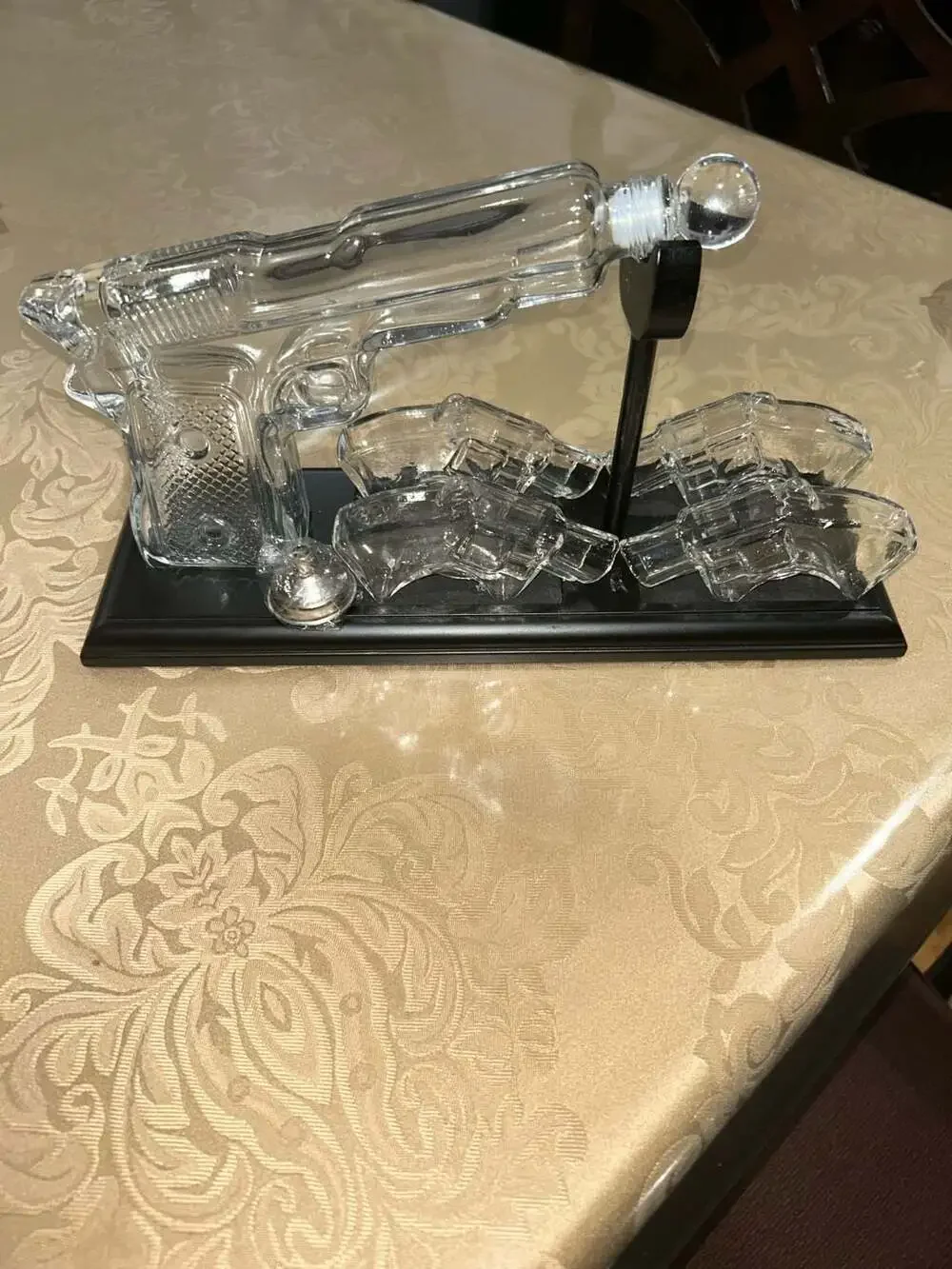 Clear Glass Pistol Decanter Set with Four Glass Shot Glasses on Display Stand